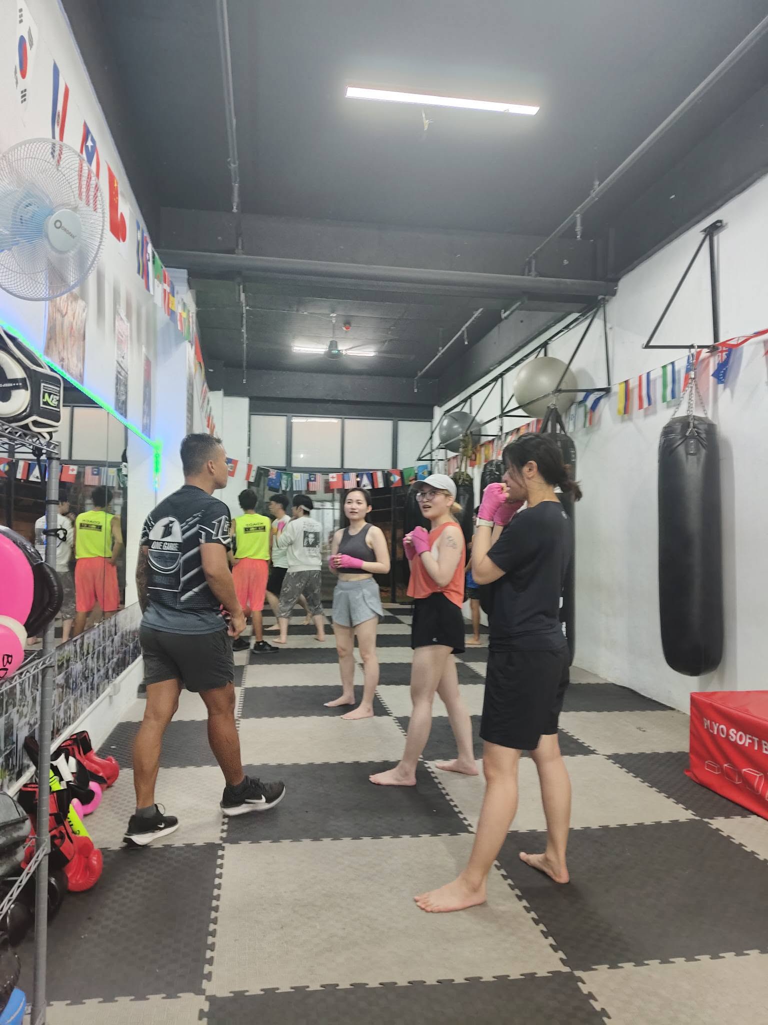 A coach guiding a group through their boxing stance